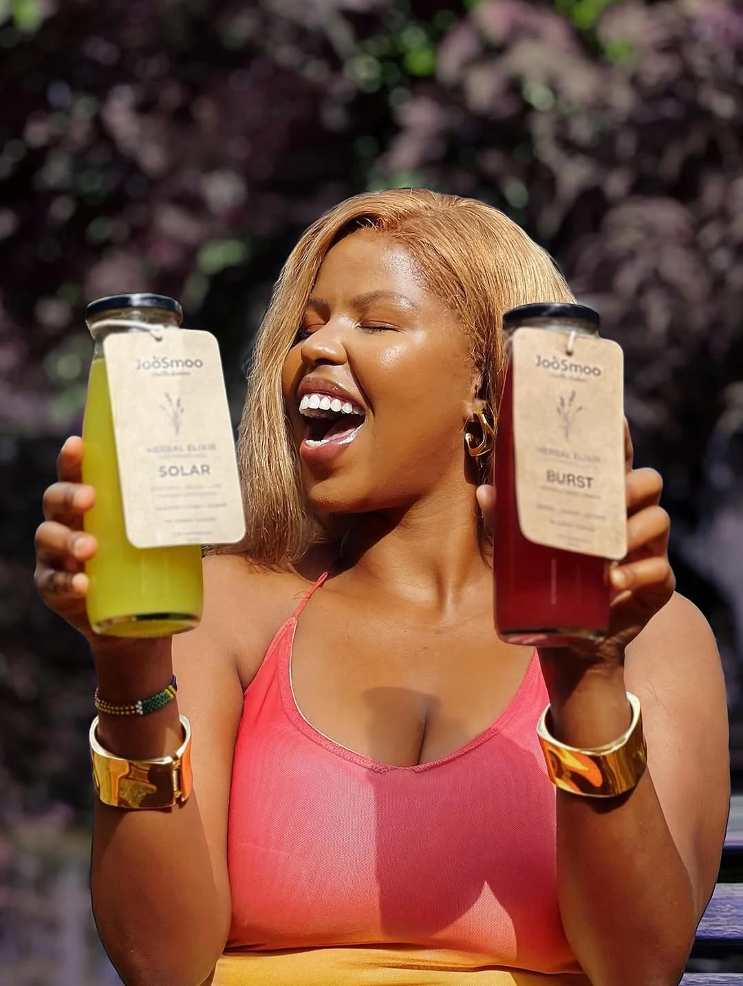 A smiling customer holding two JooSmoo drinks