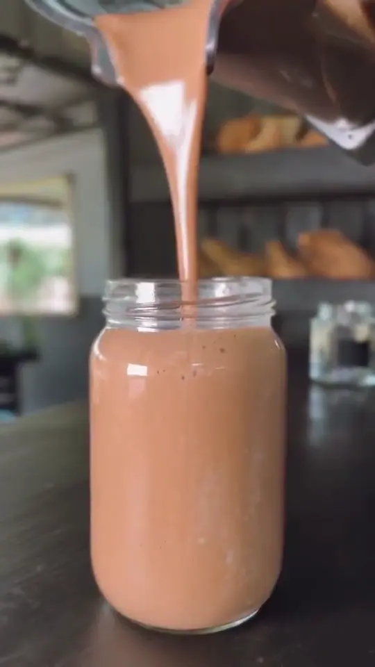 A creamy JooSmoo smoothie being poured